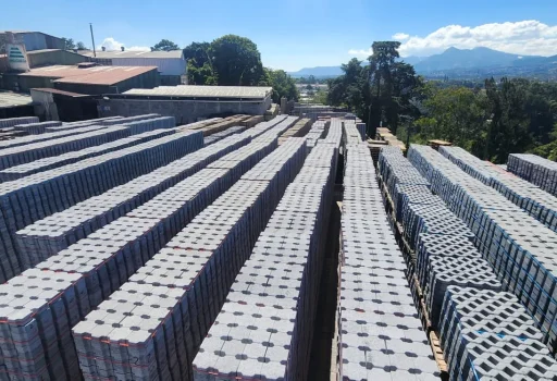 Filas de adoquines ecológicos y bloques de cemento apilados para proyectos de pavimentación exterior y urbanismo.