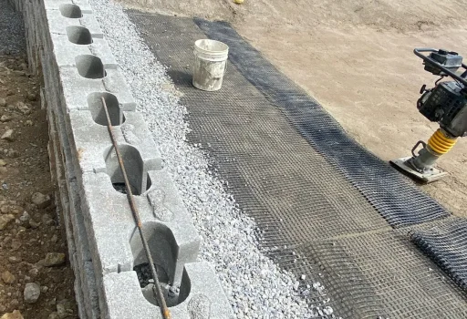 Proceso de estabilización de taludes mediante la instalación de un muro de retención modular en terreno inclinado.